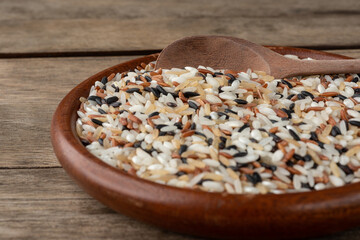 Narrow focus, closeup of assorted rice on a plate over wooden table