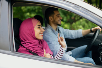 Side View Shot Of Happy Young Muslim Couple Enjoying Car Ride Together