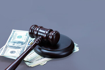 Wooden gavel and american dollars on gray background 