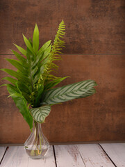 Vase with exotic leaves on brown pattern