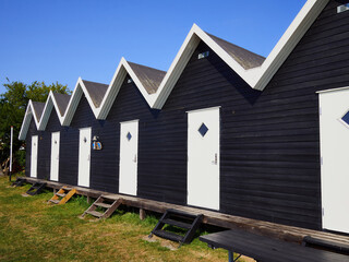 Fototapeta na wymiar Beautiful black painted fishing huts cabins on the coast