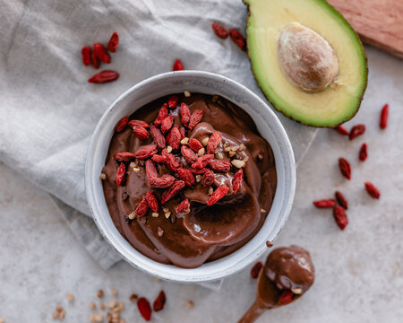 A bowl of avocado chocolate mousse with goji berries