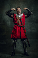 Comic portrait of funny medieval warrior or knight with dirty wounded face holding sword isolated...