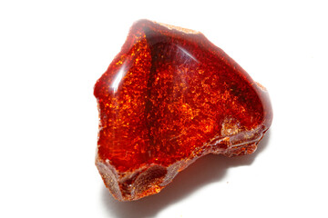 Red amber on a white background. Patterns of yellow color in the mineral. Decorations. Sun stone. Jewelry material. Ancient fossilized resin. Copal. Crystal. Geology. colored resin 
