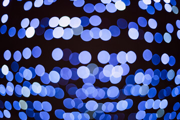 blue Sparkling Lights Festive background with texture. Abstract Christmas twinkled bright bokeh defocused and Falling stars. Winter Card or invitation.
