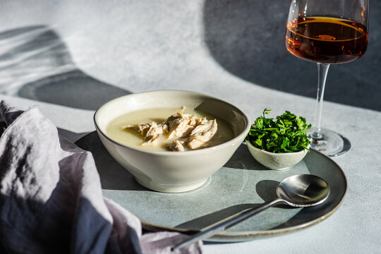 Traditional Georgian Chikhirtma chicken soup  with a glass of wine