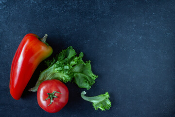 peppers, lettuce, tomatoes on a blue background, copy space