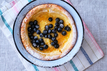 Dutch pancake with blueberries and powdered sugar. Top view.