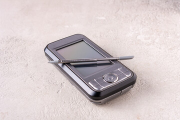 smartphone and stylus on gray plaster, selective focus