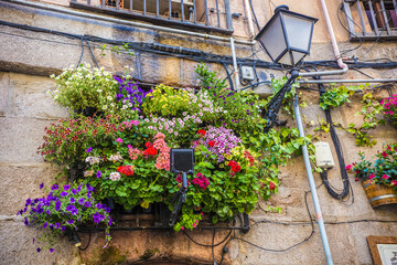 Traditional Madrid street and houses decorated with flowers, cafes and restaurants of Madrid, Spain