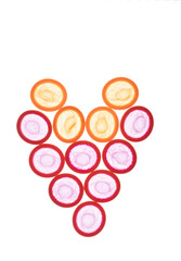 Close up view to group of unrolled red and orange condoms arranged in heart-shape formation. Concept of romance and safe relationship