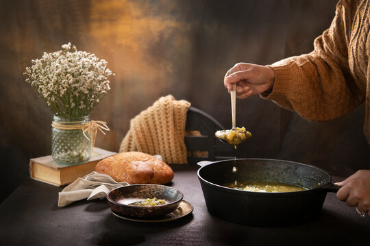 Woman's hand serving soup 