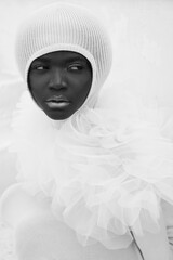 Alien. African beautiful model with perfect body in white tulle ruffles. Chocolate skin. Minimalistic background. Calm and balance
