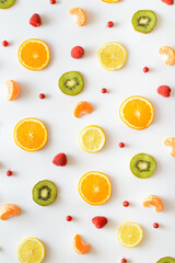 Colorful pattern made of organic fruits. Kiwi, oranges, berries and other delicious fruits on a white background.