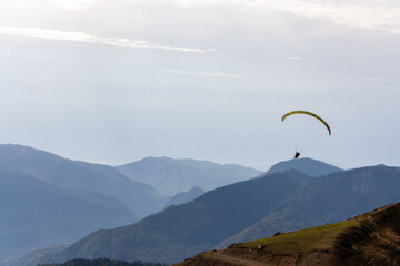 A man with a paraglider on a background of mountains