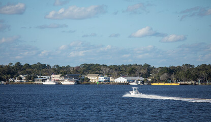 A motorboat moves across the water toward St Marys, Georgia waterfront.