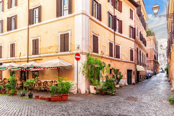 Fototapeta premium Traditional cozy Italian street with a cafe near Coliseum, Rome, no people
