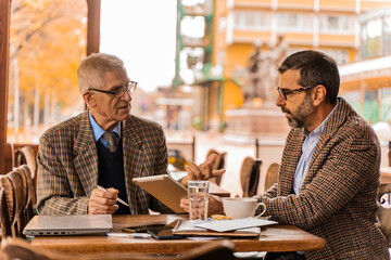 Discussing the documetns on the tablet while looking at them in the cafe