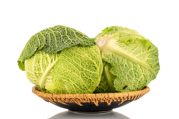 Two bales of organic Savoy cabbage with a ceramic dish, macro, isolated on white.