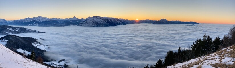 Sonnenuntergang über dem Nebel der Stadt Salzburg mit dem Untersberg