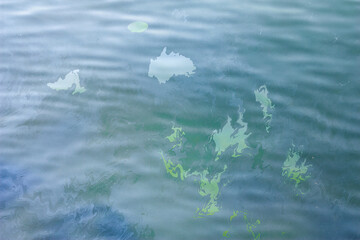 A large abstract stain from engine oil or gasoline spilled on the surface of the sea. Marble abstract background.