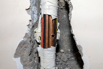 Damaged copper pipe in a wall