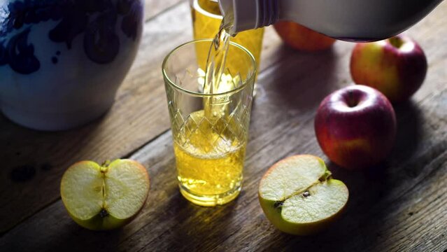 Pouring a glass of Apfelwein, Bembel and apples - traditional hessian drink, Apfelwein - apple wine - is a very strong kind of cider drink which is typical for the Rhein-Main-Area in Germany