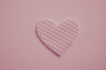 Fabric heart on pale pink table. Art card