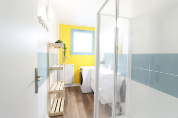 Bathroom with a shower with yellow and light blue wall.Washbasin cabinet
(France - 19.08.2020)