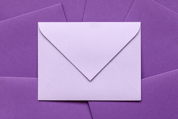 Envelope on pile of envelopes. Gift envelope purple color for congratulation. Gift certificate