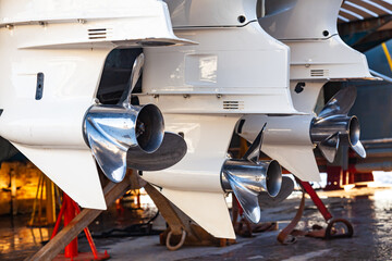 Outboard motor propellers at the stern of a motorboat in dry dock.