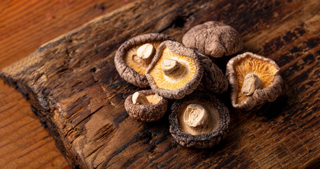 Dried shiitake mushrooms on a wooden background close up, banner for web site