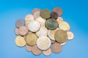 a handful of euro cent coins on a blue background