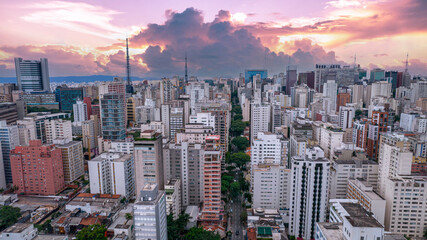 Fototapeta premium Aerial view of Av. Paulista in São Paulo, SP. Main avenue of the capital. With many radio antennas, commercial and residential buildings. Aerial view of the great city of São Paulo. Sunset