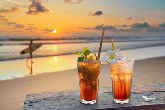 drinks with blur tropical beach and sunset in background