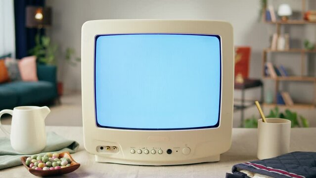 Old television with grey blank screen on home background living room. Close-up of vintage tv on kitchen table, nostalgia.