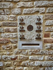 Briefkasten und Klingeln aus Bronze-Köpfen in einer Mauer in Venedig, Italien