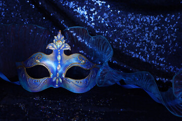 Photo of elegant and delicate Venetian mask over blue dark background