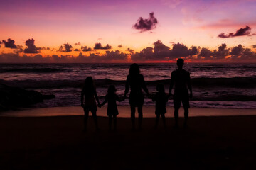 Fototapeta na wymiar Family at sunset near the ocean .Contours of people.