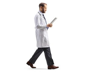 Full length profile shot of a doctor walking and looking at a document