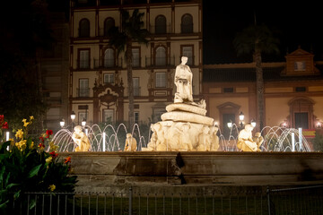 Night view of the Fountain of Hispalis or Fountain of Sevilla located in the Puerta de Jerezv square in downtown Seville, Andalusia, Spain. 