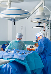 Medical team performing surgical operation in modern operating room