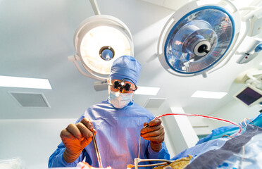 Neurosurgeon in special surgery glasses provides operation. Careful attentive doctor in operating...