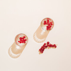 Drink glasses  with currants on a cream background. Berry juicy cocktail concept.