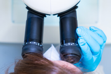 Professional female scientist doing experiment with electronic microscope in scientific genetic...