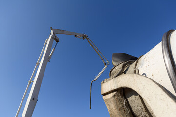 Truck mounted сoncrete pump and concrete mixer at a construction site. Concrete pouring...