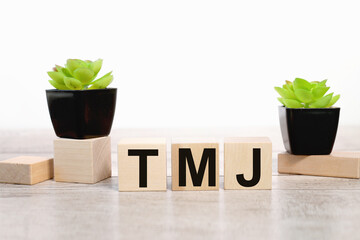 TMJ - acronym from wooden blocks with letters, abbreviation TMJ temporomandibular joint syndrome, 3...