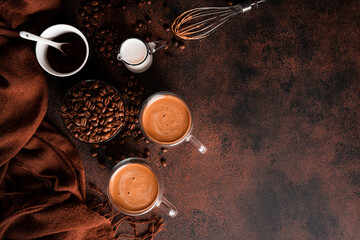 Coffee cappuccino in transparent cup on dark background. Hot coffee