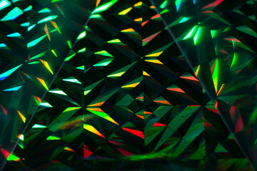 Abstract green and red grainy background with light triangles on black background.