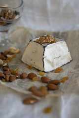 Various types of cheese with white mold on packaging paper. Home production, natural products.